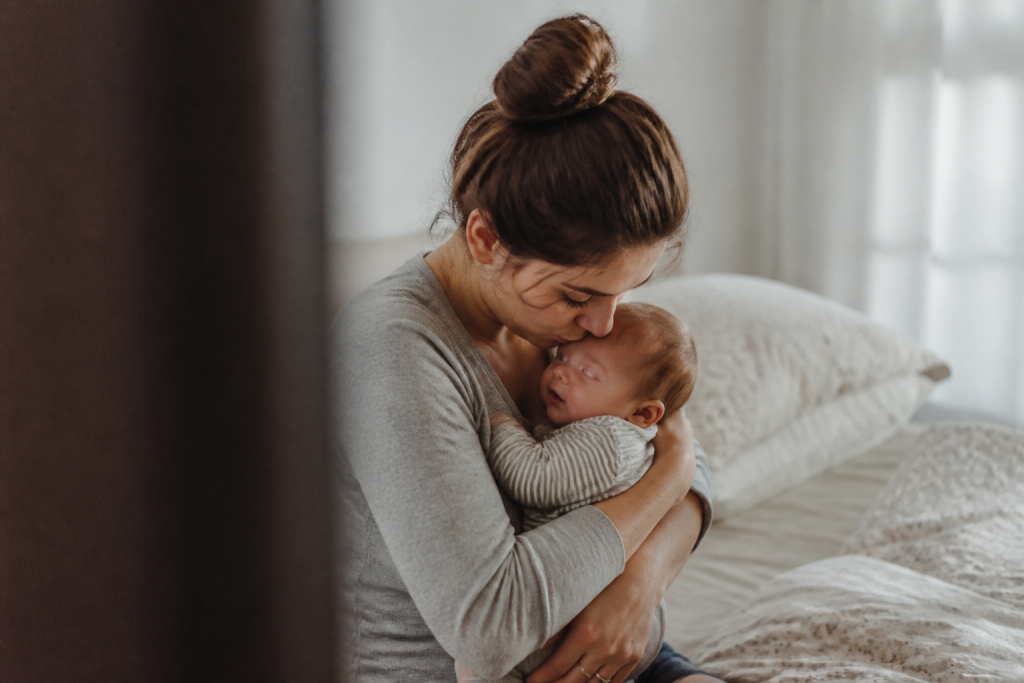 Jeune mere embrassant son nourrisson avec tendresse